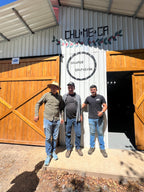 La Chumeca coffee facility entrance sign with people standing in front